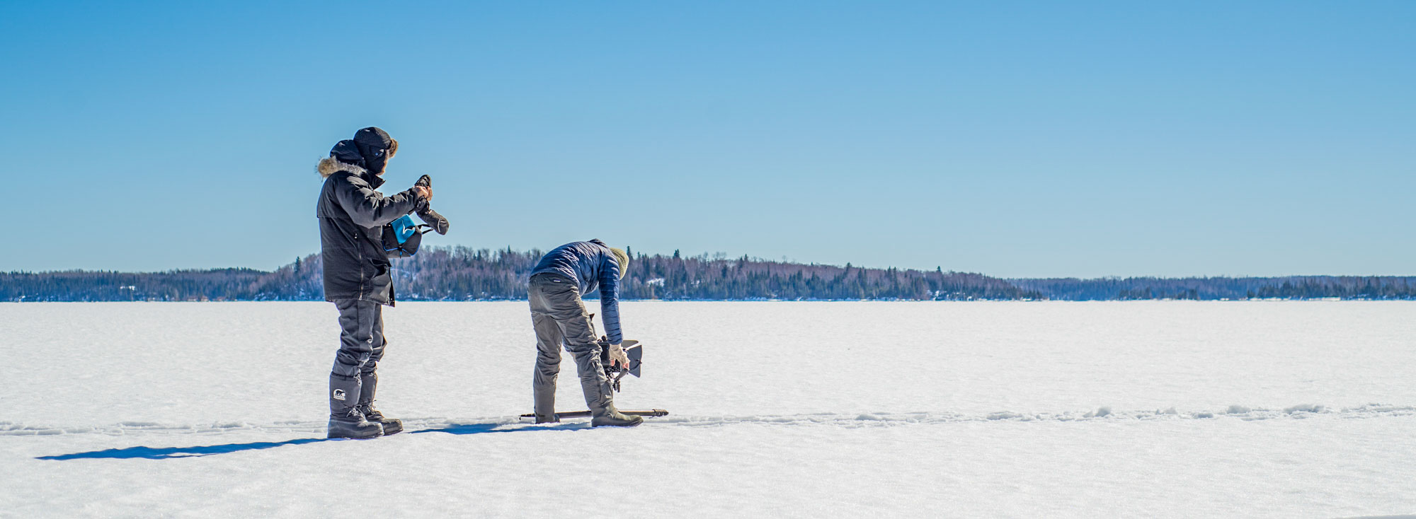 Two crew members film on a frozen lake near Red Lake, Ontario, during the Borealis shoot.